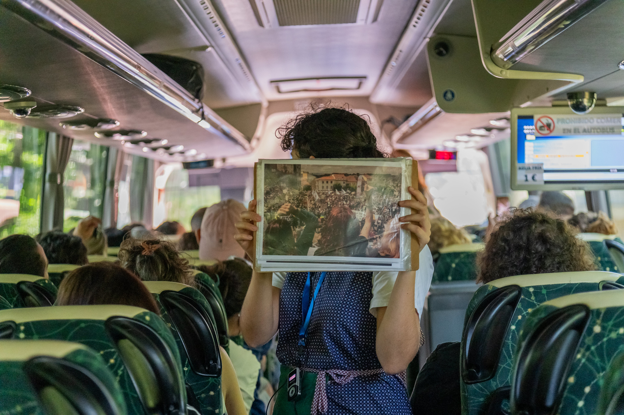 Persoa sostendo unha imaxe no interior do bus